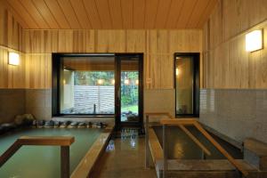 a pool of water in a room with wooden walls at Morinoryotei Biei in Biei