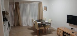 a dining room with a table and chairs and a television at Avenida Dr Baltazar Lopes da Silva 33A in Mindelo