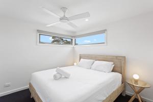 a bedroom with a white bed with a window at Stylish Townhouse Opposite Golfcourse in Cowes