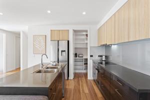 a large kitchen with a sink and a refrigerator at Stylish Townhouse Opposite Golfcourse in Cowes