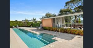 a swimming pool in front of a house at Stylish Townhouse Opposite Golfcourse in Cowes