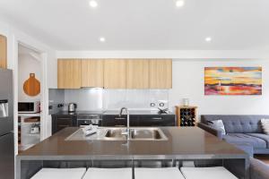 a kitchen with a sink and a couch at Stylish Townhouse Opposite Golfcourse in Cowes +20 photos
