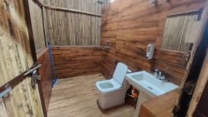 a bathroom with a toilet and a sink at Kutuumb Morni Hills in Morni