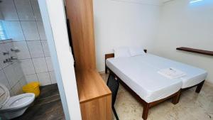 a small room with a bed and a shower and a toilet at Jo Homes Apartments in Alwaye +24 photos