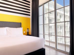 a bedroom with a white bed and a large window at Stallionz Ipoh by ANGO in Ipoh +32 photos