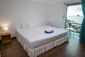 a bedroom with a bed with a view of the ocean at Mam Kaibae Hotel in Ko Chang