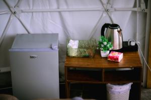 a table with a refrigerator and a tea kettle on it at Inthanon Mountain Camp in Ban Na Yang