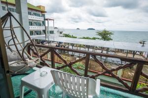 a balcony with a table and chairs and the ocean at Mam Kaibae Hotel in Ko Chang