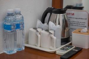 a counter with a coffee maker and two bottles of water at Mam Kaibae Hotel in Ko Chang