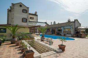 a house with a swimming pool with potted plants at Villa Malom Luxury Resort in Pusztazámor