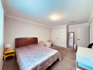 a bedroom with a bed and a table and chairs at A Zen Tea Sanctuary in Australia in Schofields