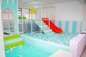 ein Zimmer mit einem Spielplatz mit Rutsche und Felsen in der Unterkunft Sunset Stays near UN, Two Rivers & Village Market with Gym & Pool in Ruaka