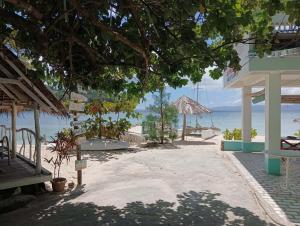 a beach with tables and chairs and the ocean at Casa Nenen in Romblon +10 photos