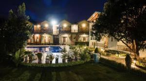 a large house with a swimming pool at night at Corbett Nirvana Resort in Amgarhi