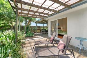 a patio with chairs and a pergola at Mudjimba Esp Villa-Beachfront-Pet friendly in Mudjimba