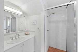 a white bathroom with a sink and a shower at Mudjimba Esp Villa-Beachfront-Pet friendly in Mudjimba +14 photos
