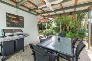 a patio with a grill and a table and chairs at Mudjimba Esp Villa-Beachfront-Pet friendly in Mudjimba