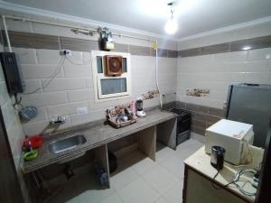 a small kitchen with a sink and a microwave at Pink Horizon Homestay - for Men ONLY in Dumyāţ al Jadīdah