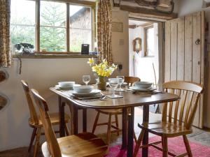 a dining room table with chairs and a table and a window at Titchbourne Cottage in Clee Saint Margaret