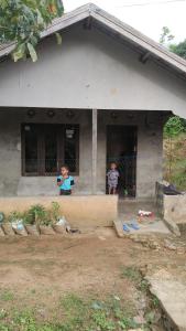 two children standing in the window of a house at Kotabaru in Gununganjar