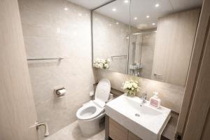 a bathroom with a toilet and a sink and a mirror at 더 디셈버스테이 인 한라 in Taeam