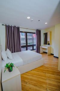 a bedroom with a large white bed and a window at Olive Town Center and Hotel in Baguio +35 photos