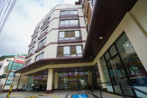 a tall building on a city street at Olive Town Center and Hotel in Baguio