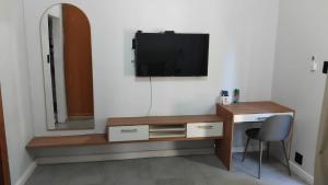 a room with a desk and a television on a wall at White House River Manor in Upington