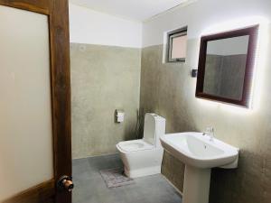 a bathroom with a toilet and a sink at Elephant Trail Homestay in Habarana