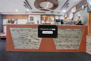 a restaurant with a stone counter with a sign on it at Super Townhouse Oak Dharwad New Bus Terminal Formerly Hotel Aditya Inn in Dhārwād