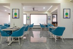 ein Esszimmer mit blauen Stühlen und Tischen in der Unterkunft Treebo Iris Executive, Hinjewadi in Pune