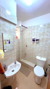 a bathroom with a toilet and a sink and a tub at Polea Tatu in Ngong