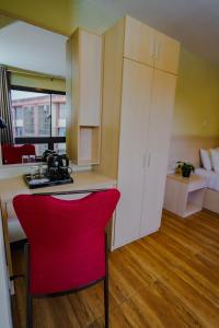 a kitchen with a red chair in a room at Olive Town Center and Hotel in Baguio