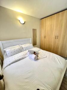 a white bed with a stuffed animal laying on it at Polea Tatu in Ngong
