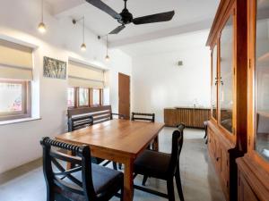 a dining room with a wooden table and chairs at Serendipity in Colombo +8 photos
