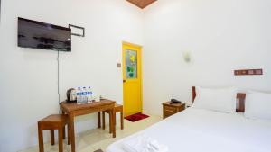 a bedroom with a bed and a yellow door at Dambulla Village Hotel in Dambulla