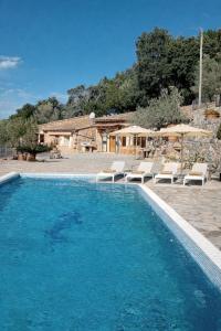 a large swimming pool with chairs and a house at Cozy Chalet with Sea Views & Private Pool in Valldemossa