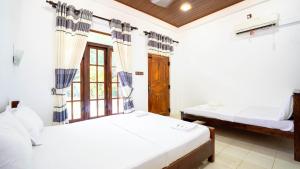 a bedroom with two beds and a window at Dambulla Village Hotel in Dambulla +117 photos