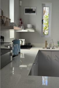 a white kitchen with a sink and a window at McGregor Hideaways in McGregor +29 photos