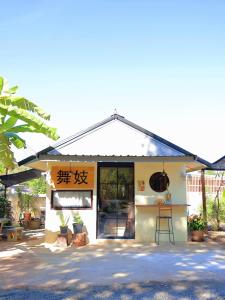 a small building with writing on the side of it at chananthida suyarach in Ban Mai Na Hi