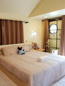 a large bed with a cat sitting on top of it at chananthida suyarach in Ban Mai Na Hi