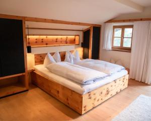 a bedroom with a large bed with a wooden headboard at Fannys in Weißach