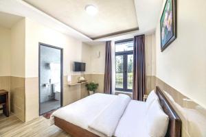 a bedroom with a bed and a large window at Hamilton Villa Da Lat - Pine Tree n Valley View in Khu Chi Lăng