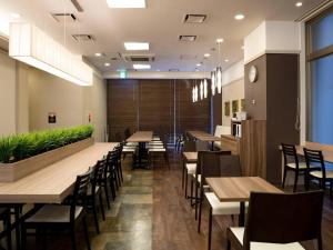 a dining room with wooden tables and chairs at Comfort Hotel Yamagata in Yamagata