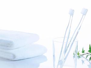 two toothbrushes in a glass next to a stack of towels at Comfort Hotel Yamagata in Yamagata +17 photos