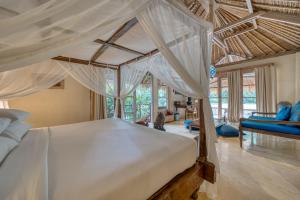 a bedroom with a large bed with white canopy at Nomadic Resort Bali in Canggu +41 photos