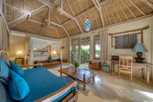 a bedroom with a bed and a living room at Nomadic Resort Bali in Canggu