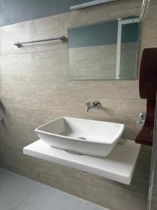 a bathroom with a white sink and a mirror at Mount Rivera in Atabage Pallegama