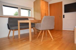a wooden table and two chairs in a room at Ferienwohnung Davenna in Vandans