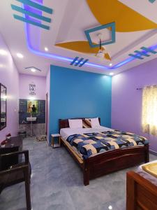 a bedroom with a bed and a blue wall at HAMPI STAy in Hampi +30 photos